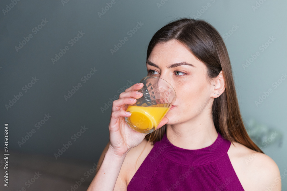 Pretty young woman drinking fresh orange juice at home Pretty young woman drinking fresh orange juice at home