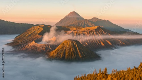 4k Timelapse Movie Sunrise Scene of Moving Cloud, Fog and Smoke of Eruption Cover Volcano Mts. Bromo, Semeru, Batok and Widodaren, Tengger Caldera, Indonesia photo