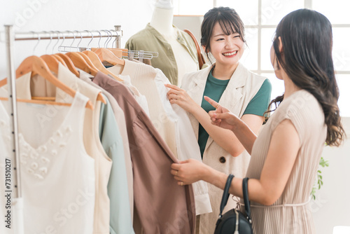 アパレルショップで洋服を買い物・ショッピングする女性とショップ店員
 photo