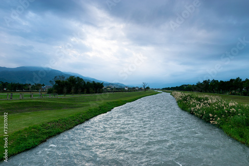 View from Annong river in cloudy day and green lawn by the sides in Yilan , Taiwan.