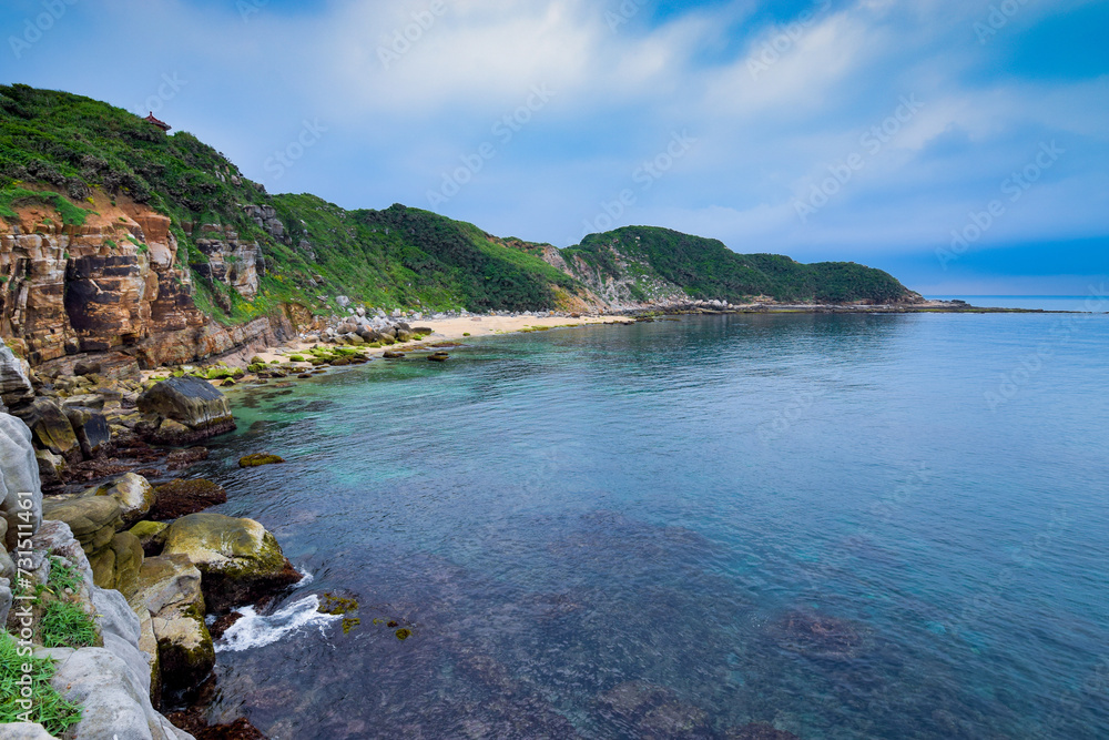 Secret beach hidden in the bay, with clean blue ocean and beautiful rocks on it, in Jinshan, New Taipei City, Taiwan.