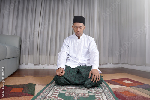 Muslim Man Praying In Tashahhud Posture photo