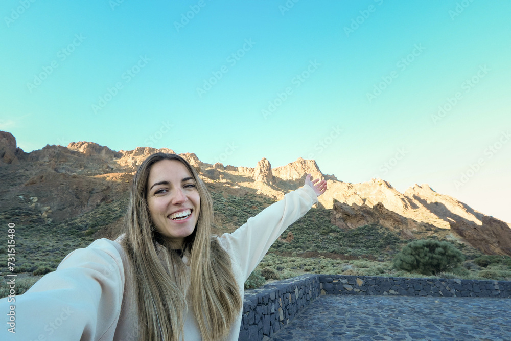 Smiling Woman Taking a Selfie in a Mountainous Landscape at Dusk