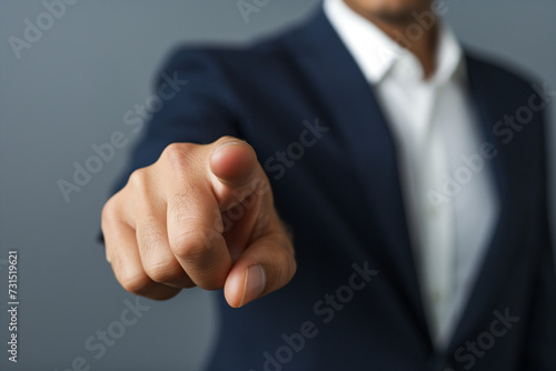 Businessman in suit pointing with hand, conveying success and agreement gesture