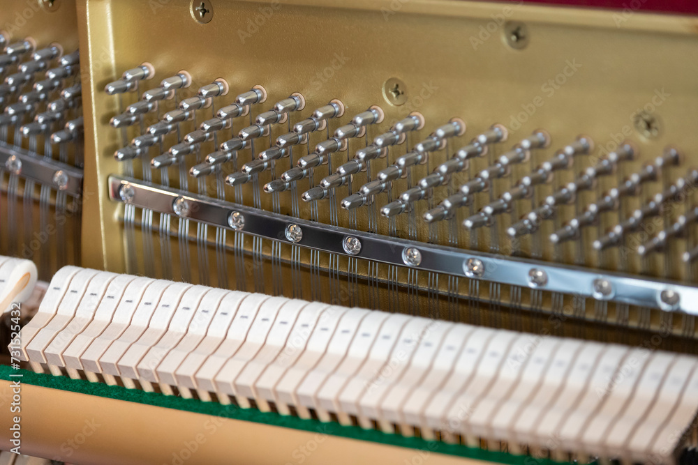 Close-up shallow focus image of the internal mechanisms of an upright piano. It gives a feeling of luxury, beauty, classic, sophistication, elegance. Image can be use for various topics about music. Close-up shallow focus image of the internal mechanisms of an upright piano. It gives a feeling of luxury, beauty, classic, sophistication, elegance. Image can be use for various topics about music.