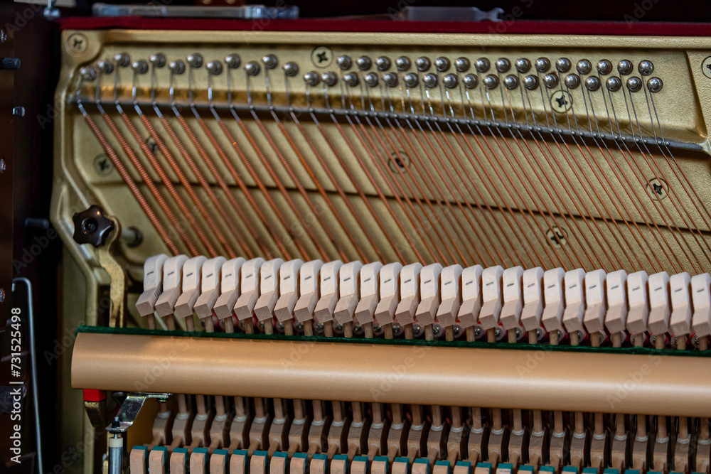 Close-up shallow focus image of the internal mechanisms of an upright piano. It gives a feeling of luxury, beauty, classic, sophistication, elegance. Image can be use for various topics about music. Close-up shallow focus image of the internal mechanisms of an upright piano. It gives a feeling of luxury, beauty, classic, sophistication, elegance. Image can be use for various topics about music.