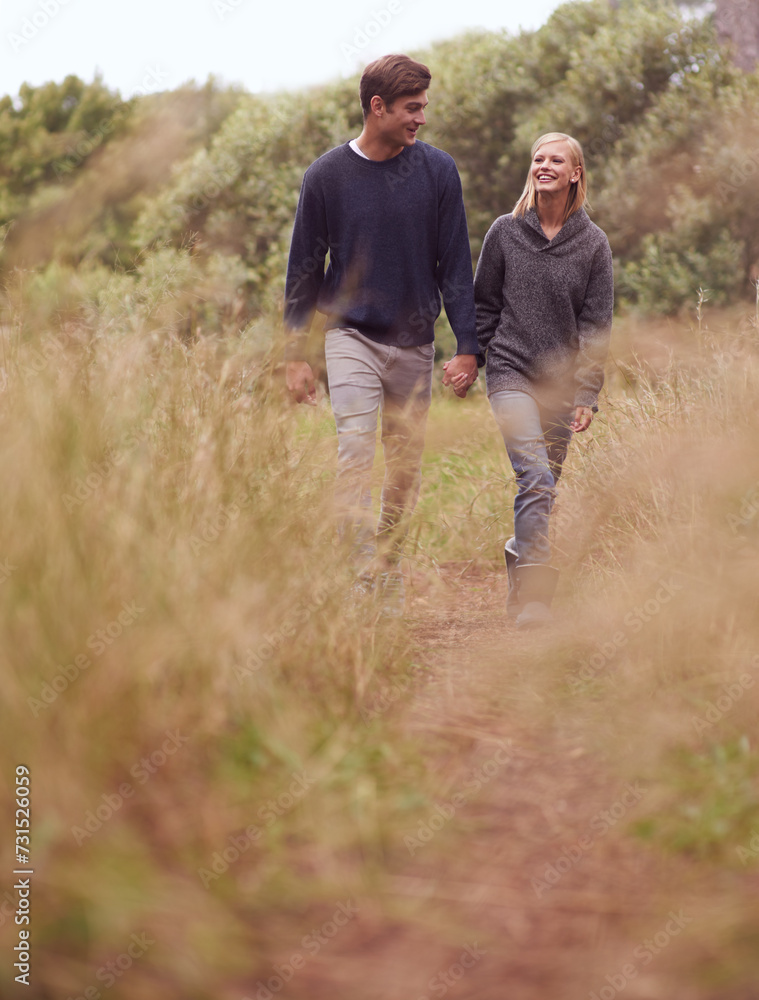 Happy couple, walking or holding hands in the countryside, nature or summer outdoor for hiking on valentines day date. Smile, man and woman at meadow for support, love or romantic connection together