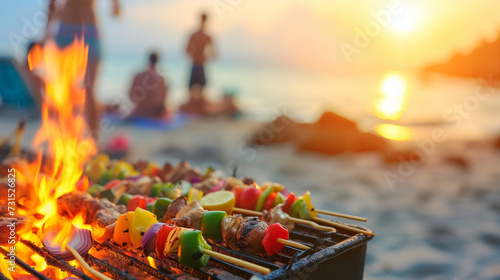 Summer bbq concept image with skewers on a hot barbecue on the beach with people in background photo