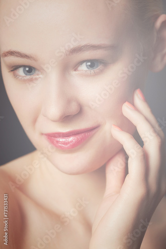Skincare, hand and portrait of woman in makeup to glow isolated on a dark studio background. Face, touch and beauty of young model in cosmetics, manicure and spa facial treatment for smooth skin