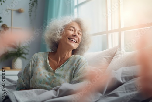 Happy fresh mature middle aged woman stretching in bed waking up alone happy concept, smiling old senior lady awake after healthy sleep sitting in cozy comfortable bedroom interior enjoy good morning. photo