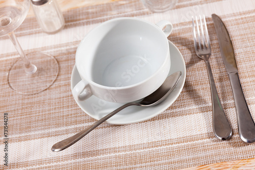 Empty bowl served to table with cutlery in restaurant