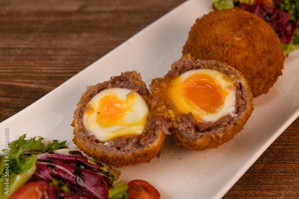 RECIPE FOR BREADED BEEF MEATBALLS STUFFED WITH A SOFT BOILED EGG. High quality photo RECIPE FOR BREADED BEEF MEATBALLS STUFFED WITH A SOFT BOILED EGG. High quality photo