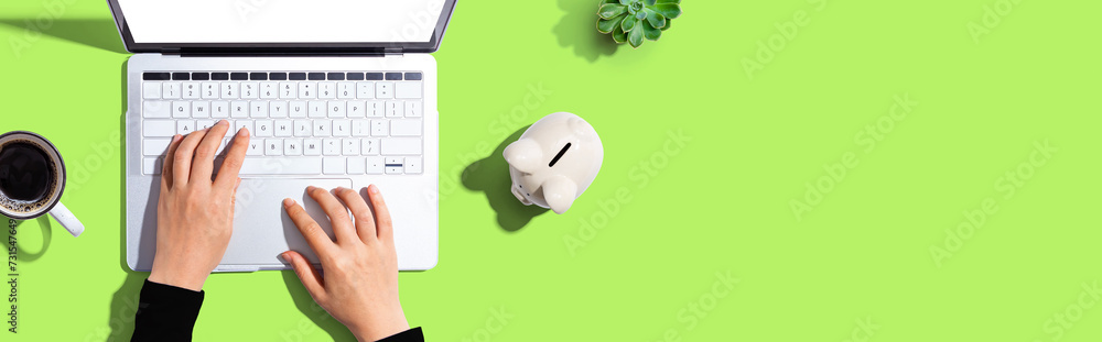 Laptop computer with piggy bank - flat lay Laptop computer with piggy bank - flat lay