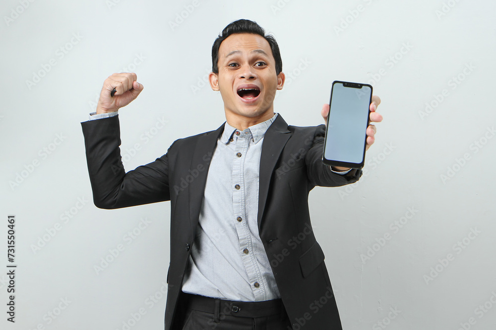 Happy confident asian indonesian business man in suit showing blank smartphone screen on isolated background Happy confident asian indonesian business man in suit showing blank smartphone screen on isolated background