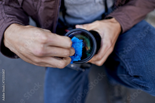 Clean, camera and lens in hands of photographer to prepare equipment for photoshoot and process. Cameraman, closeup and wipe gear to start photography outdoor with care for professional technology