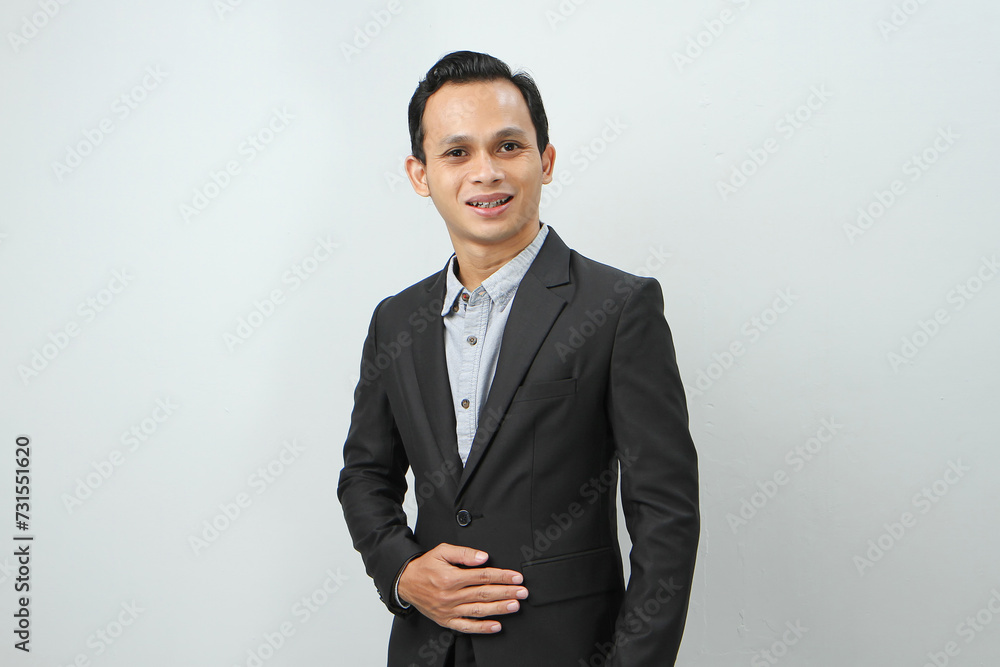 Happy confident asian indonesian business man in suit on isolated background Happy confident asian indonesian business man in suit on isolated background