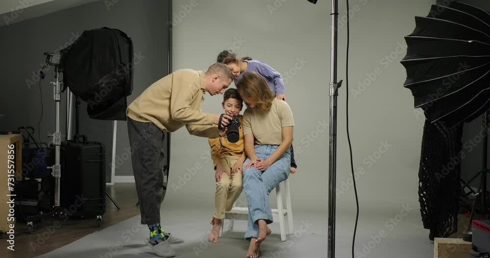 Family photo shooting. Photographer shows photos on camera. Happy ...