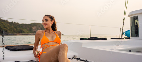 Canvas Print Caucasian young woman drinking champagne while having party in yacht