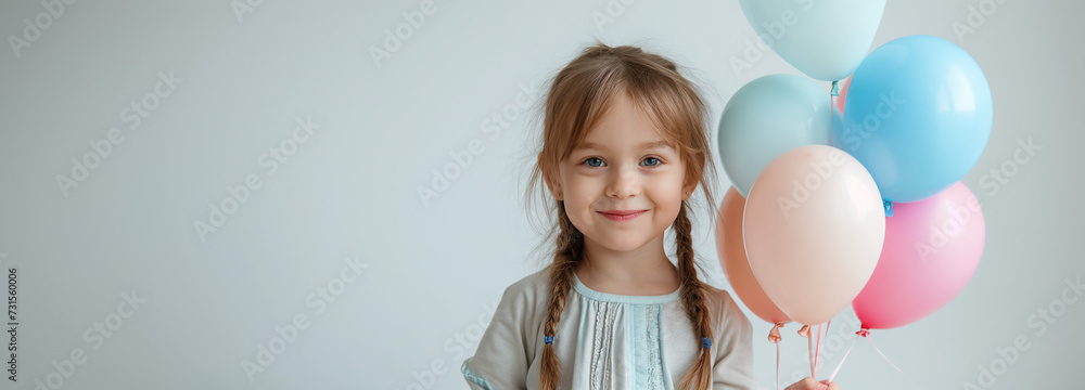 Child and girl joyfully hold colorful balloons at a festive celebration
