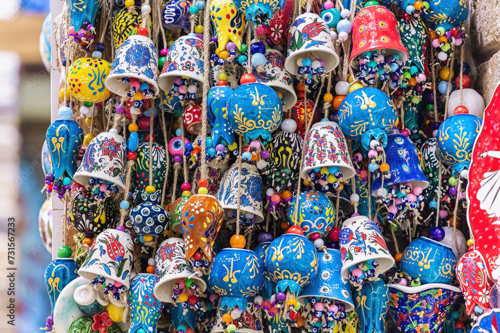 Bundles of multicolored porcelain bells and pomegranates. House decoration and amulets. Colorful souvenir in the market display. Mass product, close up. Egypt bazaar, Istanbul, Turkiye (Turkey)