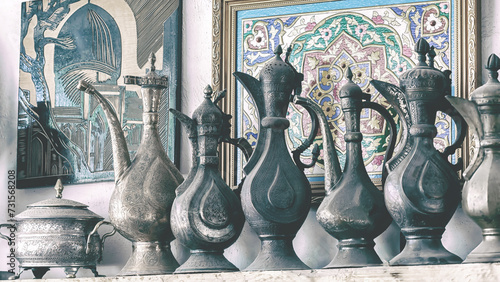 Old copper jugs stand at street antique market. Minochrome, toning. Bukhara, Uzbekistan photo