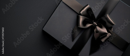 Image of a Part of Luxury gift box with black bow on black, empty copy space photo