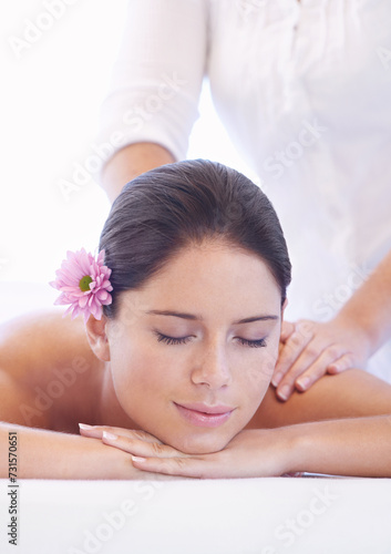 Relax, massage and woman at wellness spa with flower for health, rest and luxury holistic treatment. Self care, peace and girl on table with masseuse for body therapy, balance and calm hotel service