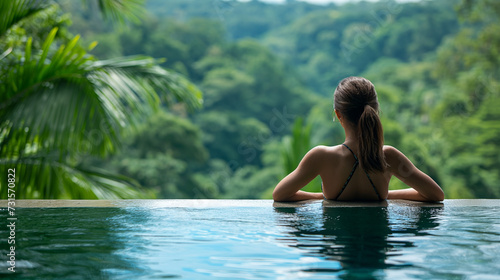 Woman with relaxing in Infinity pool with a view to the jungle © KN Studio