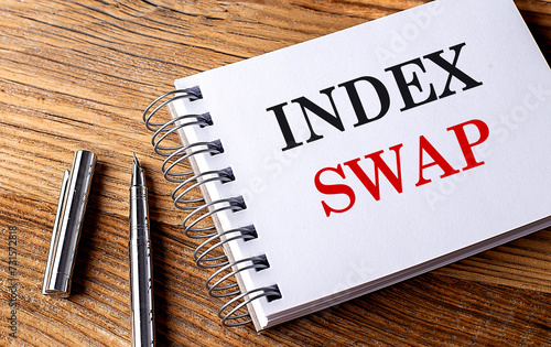 INDEX SWAP text on notebook with pen on wooden background photo