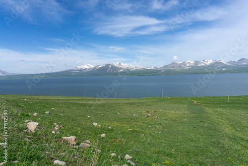 Paravani lake and mountains. Natural lake, blue water, clouds, snowy mountains and blue sky. photo