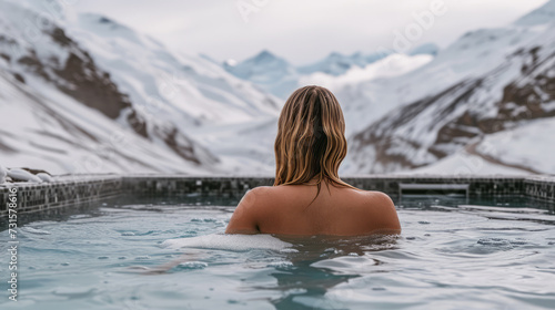 A woman enjoying a hot bath in a pool surrounded by snow-capped mountains, depicting a winter retreat and health concept. Ai generative