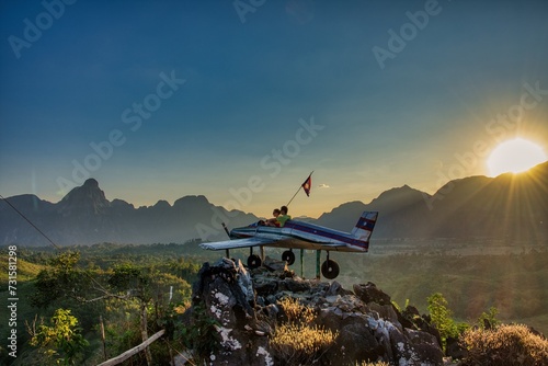 Airplane on top of mountain, Sunrise in Vang Vieng at Phapoungkham viewpoint. Airplane on the top of the mountain, Sunset time, sun goes down, amazing view photo
