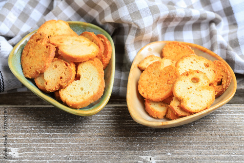 Toasted crisps seasoned with herbs on a small plate.