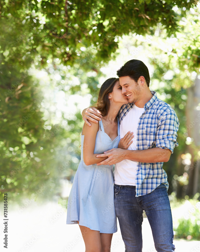 Fototapeta premium Couple, hug and happy in park with kiss in summer for partnership together or date, peaceful or embrace. Man, woman and bonding in nature backyard for relationship vacation or sun, holiday or trees