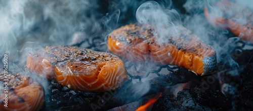 Salmon steaks grilled over open fire  engulfed in smoke.