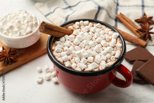Tasty hot chocolate with marshmallows and ingredients on white marble table, closeup