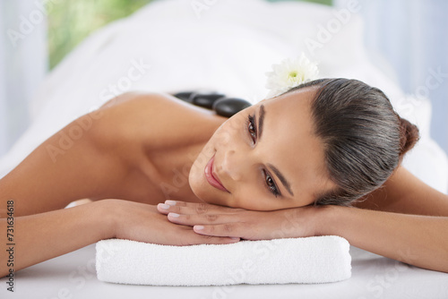 Woman, hot stone massage and treatment for relaxing, wellness and muscle therapy for body care. Female person, skin detox and satisfaction at resort, beauty and resting for skincare and peace or zen