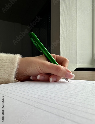 Main qui tiens un stylo vert  photo