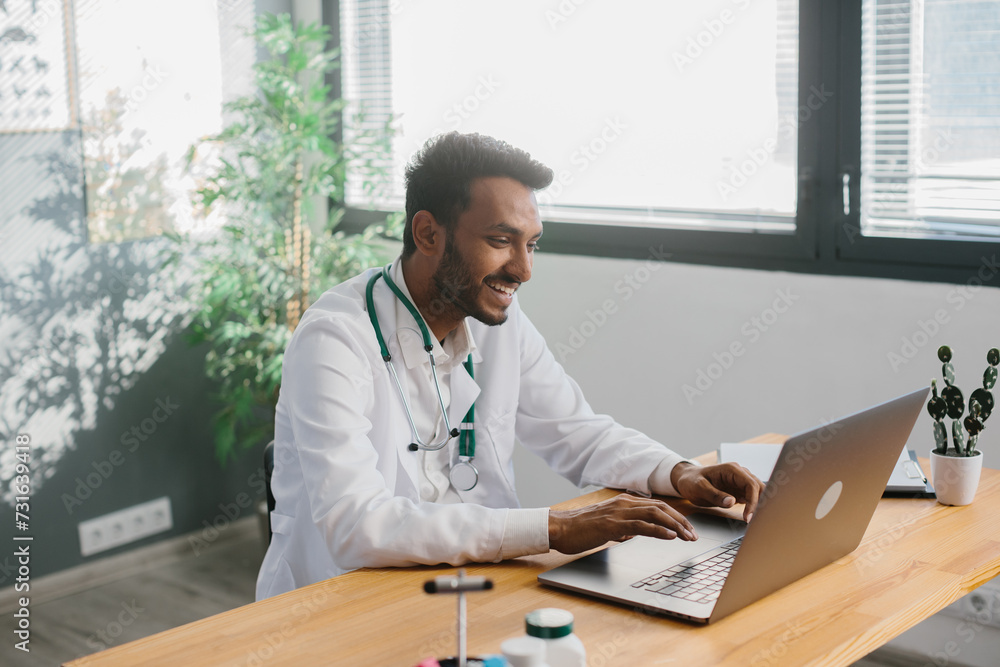 An Asian doctor uses a laptop to conduct an online consultation with a patient. An Asian doctor uses a laptop to conduct an online consultation with a patient.
