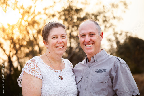 Joyful middle aged couple standing together in afternoon light - faithfulness photo
