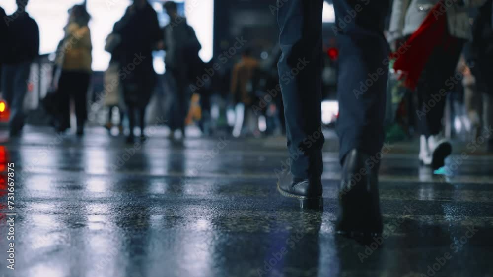 Rear back view male feet steps crossing busy street at night. Man wearing dark leather boots goes on pedestrian crossing in city. Low angle people crowd legs walking sidewalk, rainy autumn weather Rear back view male feet steps crossing busy street at night. Man wearing dark leather boots goes on pedestrian crossing in city. Low angle people crowd legs walking sidewalk, rainy autumn weather