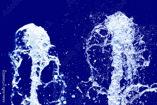 公園の噴水の水のアップ　爽やかで涼しいイメージ　青色の背景
