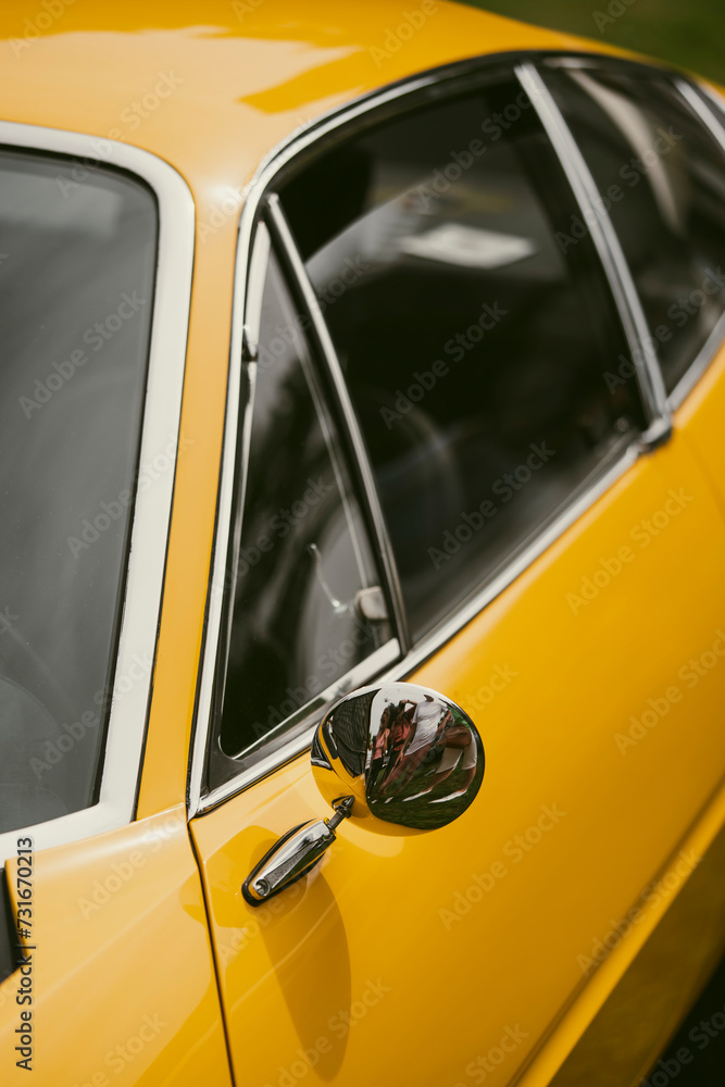Round rear view mirror on a vintage yellow car