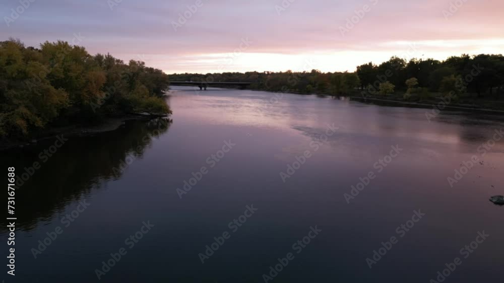 Aerial view of calm lake water surrounded by green trees during the scenic sunset Aerial view of calm lake water surrounded by green trees during the scenic sunset
