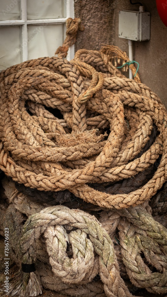 Close-up of tan-colored, thick ropes near a closed brown window