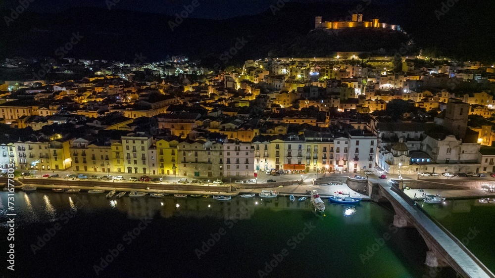 Beautiful view of white houses on the waterfront with docked yachts at late night