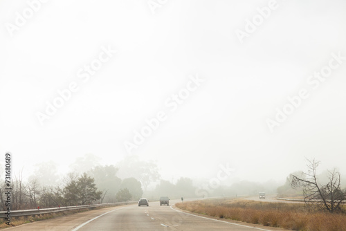 Car driving on road in hazardous condition fog photo
