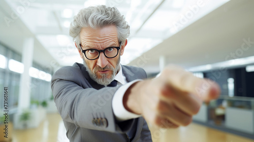 Confident senior businessman pointing forward in a modern office setting