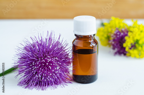 Small bottle with burdock extract (massage oil, tincture, infusion). Aromatherapy, spa and herbal medicine ingredients. Copy space.