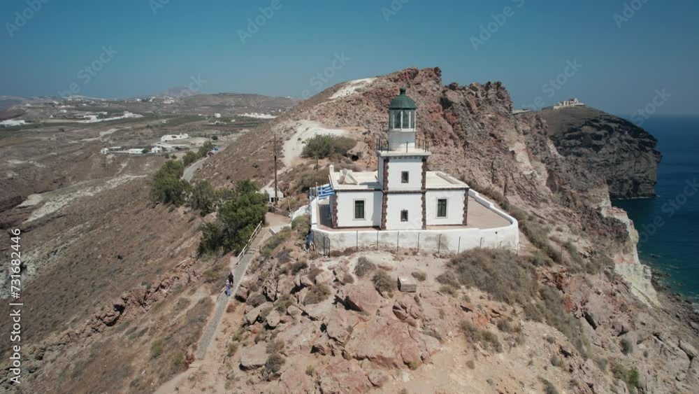 Aerial of the Akrotiri lighthouse on Santorini island surrounded by the water of Aegean sea Aerial of the Akrotiri lighthouse on Santorini island surrounded by the water of Aegean sea